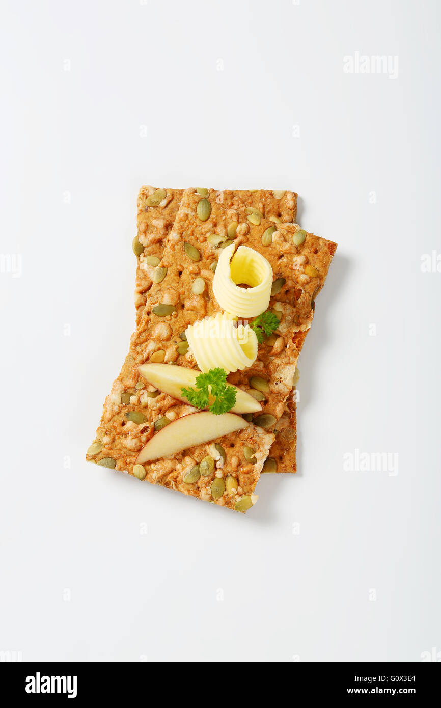 pumpkin seed crackers with butter curls and apple slices on white background Stock Photo