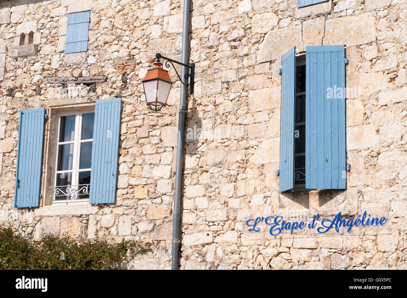 View of the facade of a house with traditional blue painted windows. La Romieu. Gers. France. Stock Photo
