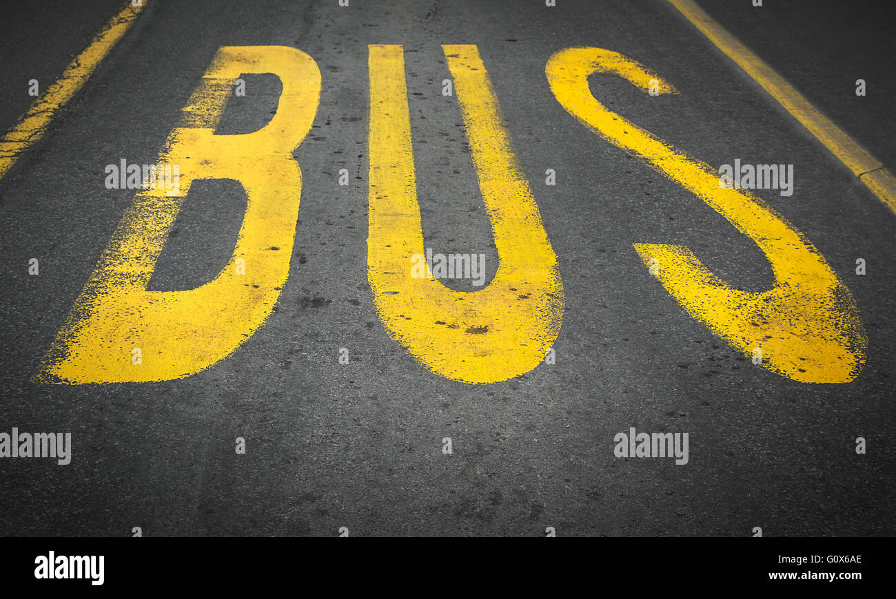 Yellow bus traffic sign painted on asphalt road. Stock Photo