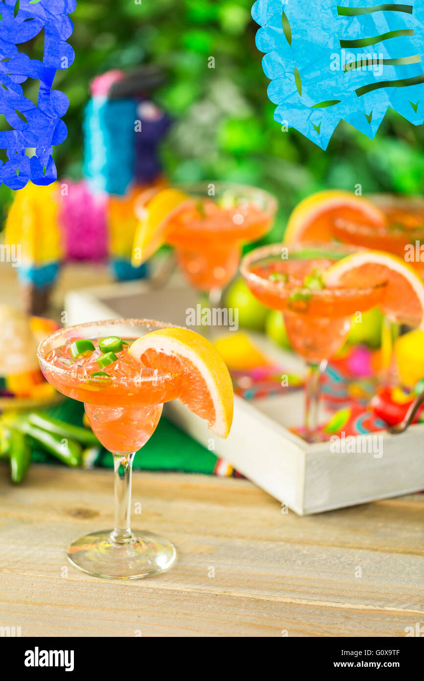 Spicy grapefruit margarita on ice in margarita glasses on the table in the garden. Stock Photo