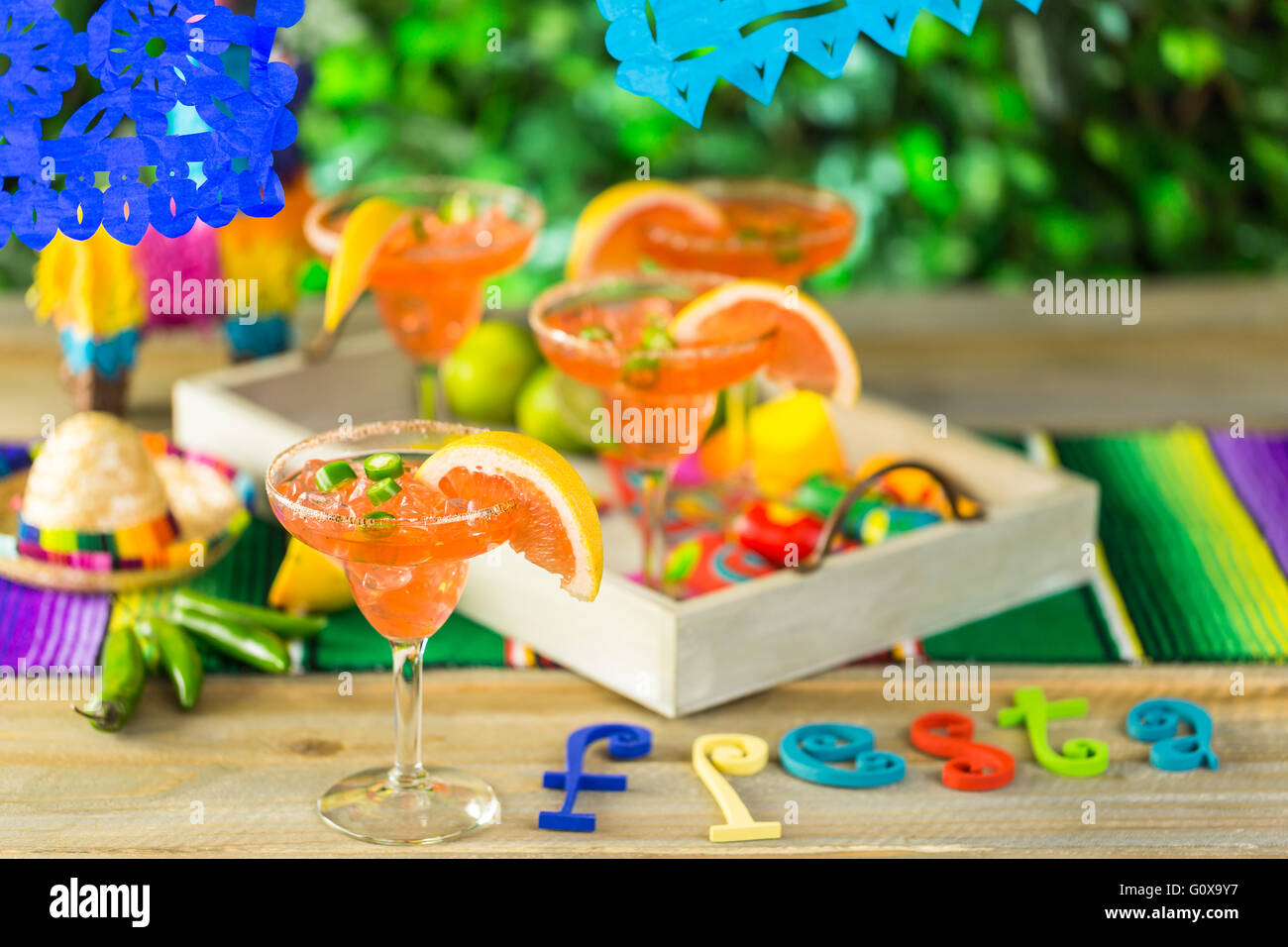 Spicy grapefruit margarita on ice in margarita glasses on the table in the garden. Stock Photo