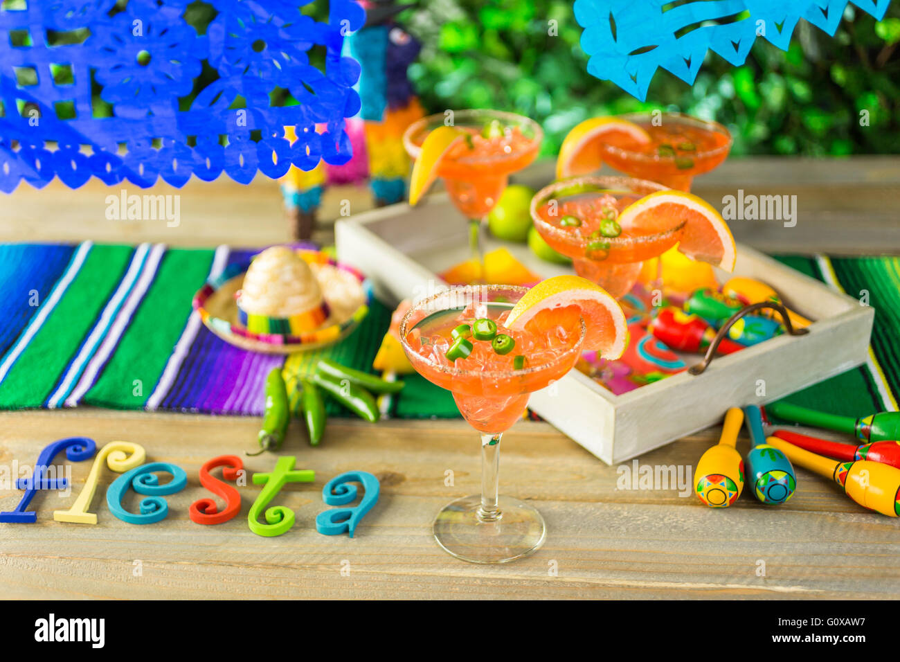 Spicy grapefruit margarita on ice in margarita glasses on the table in the garden. Stock Photo