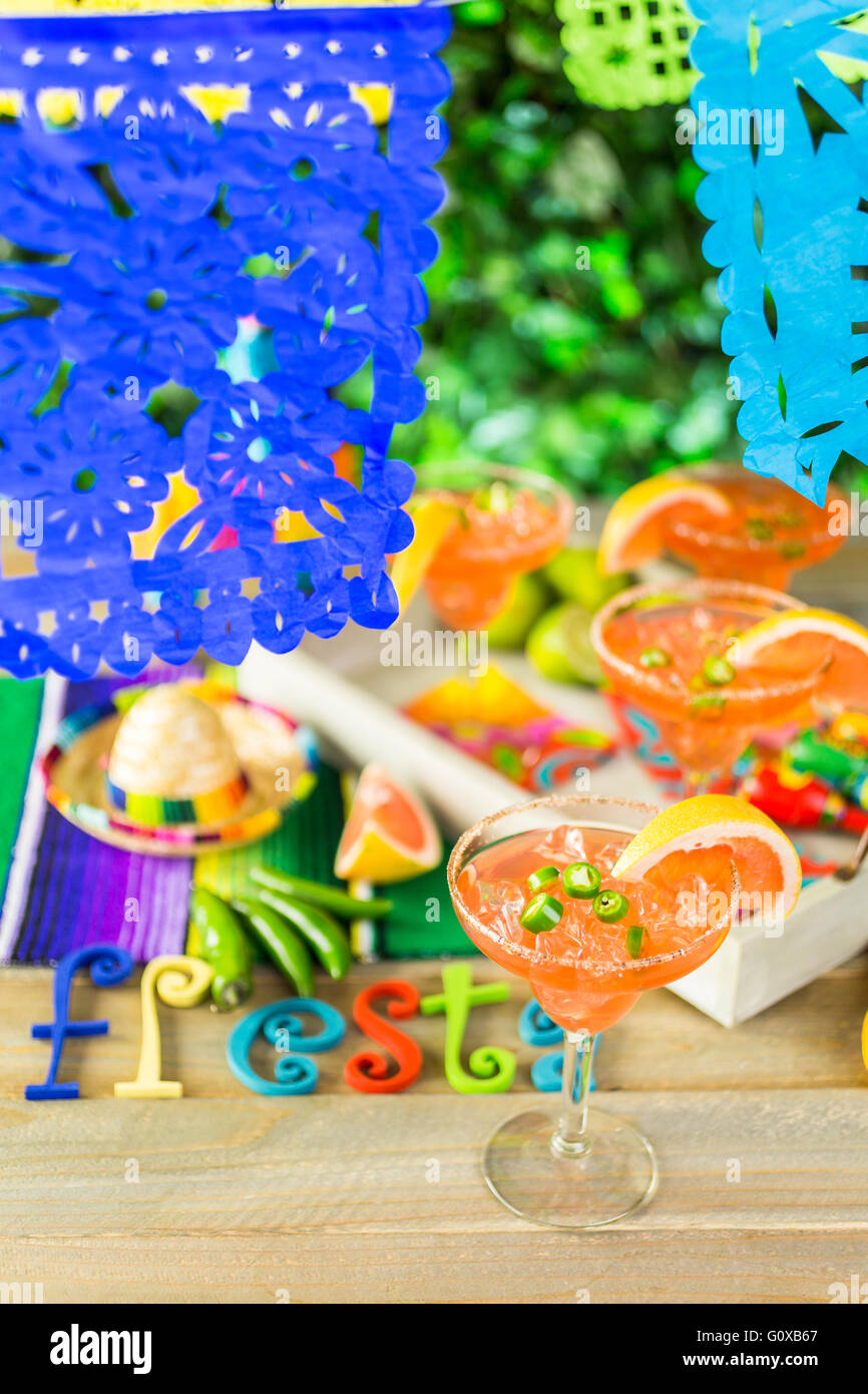 Spicy grapefruit margarita on ice in margarita glasses on the table in the garden. Stock Photo