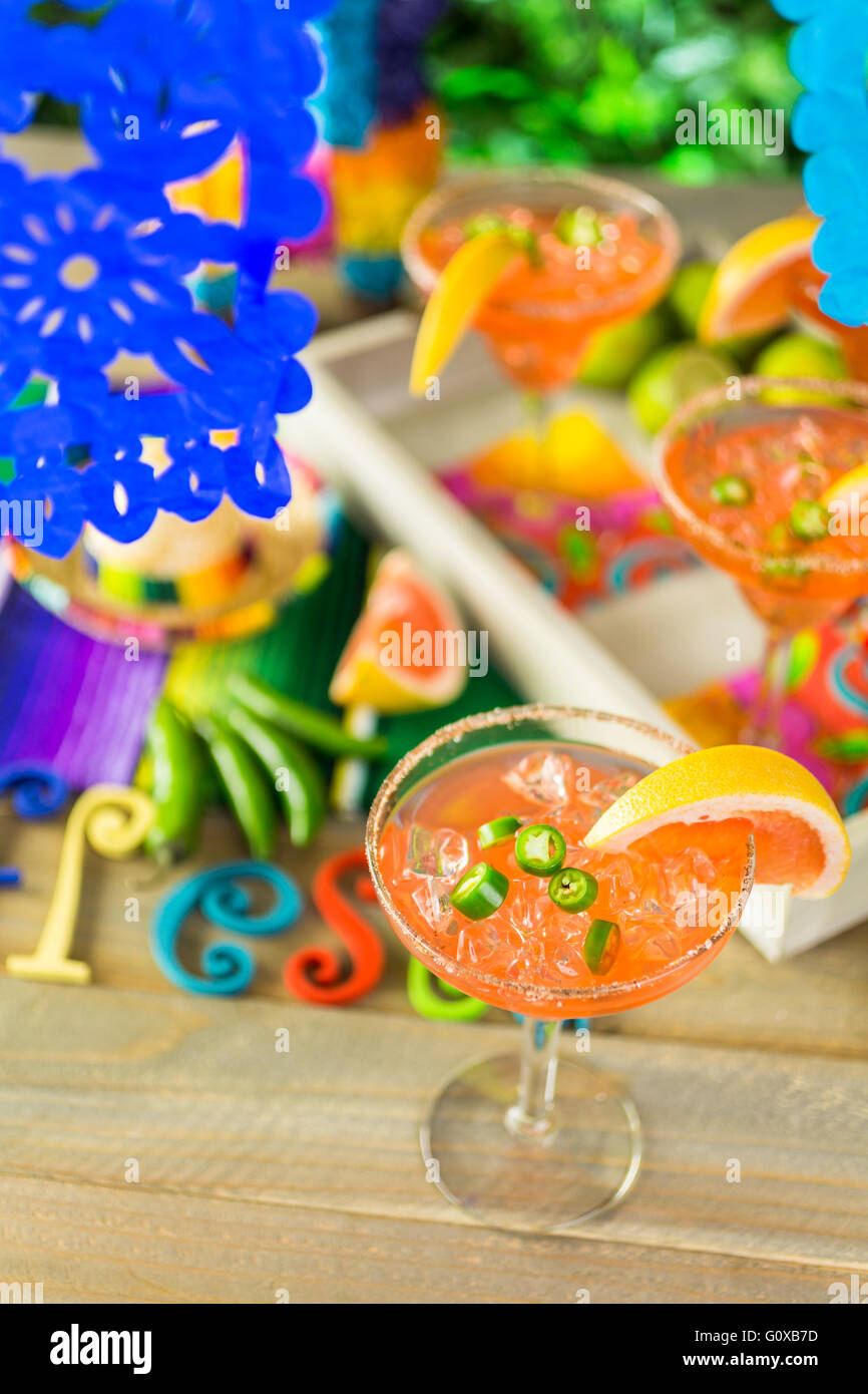 Spicy grapefruit margarita on ice in margarita glasses on the table in the garden. Stock Photo