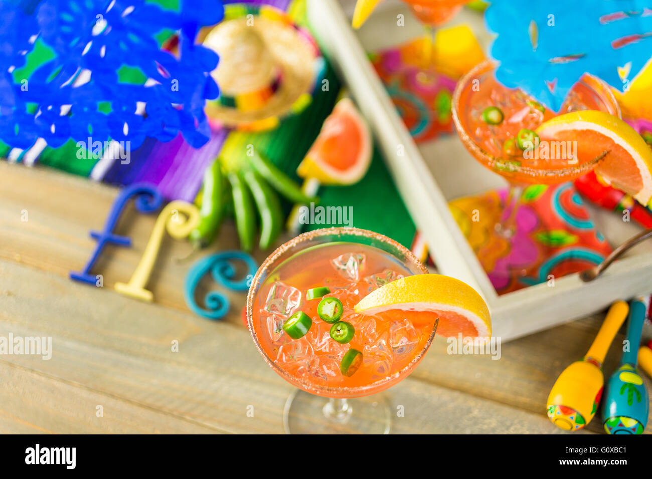 Spicy grapefruit margarita on ice in margarita glasses on the table in the garden. Stock Photo