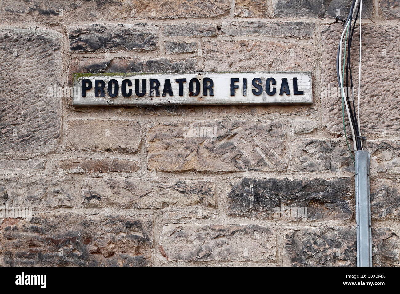 A sign on the wall of a car park in Jedburgh, Scotland, indicates where the Procurator Fiscal's car parking space is situated. Stock Photo