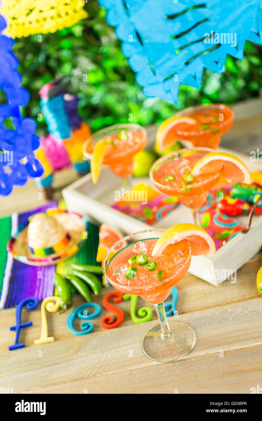 Spicy grapefruit margarita on ice in margarita glasses on the table in the garden. Stock Photo