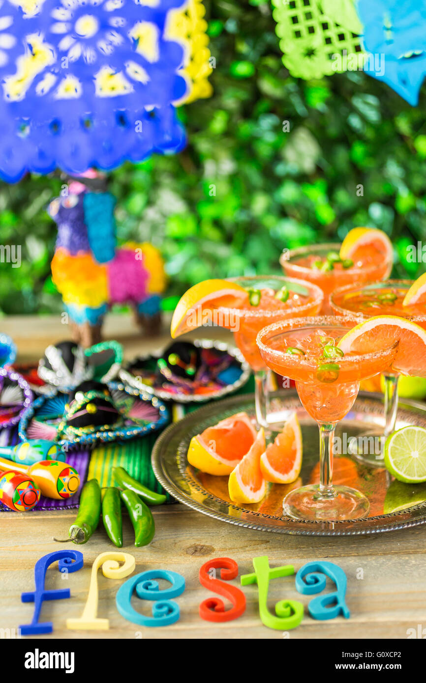 Spicy grapefruit margarita on ice in margarita glasses on the table in the garden. Stock Photo