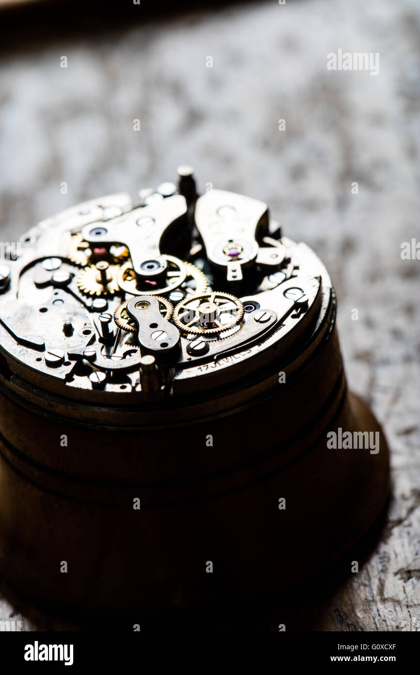 high contrast closeup of a fascinating antique watch mechanism on repair table Stock Photo