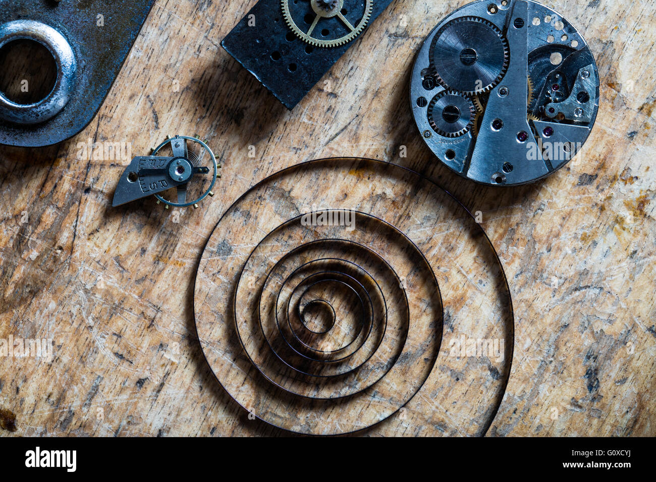 vertical view (flat layer) of a spring, balance wheel and clockworks on a table of a clockmaker Stock Photo