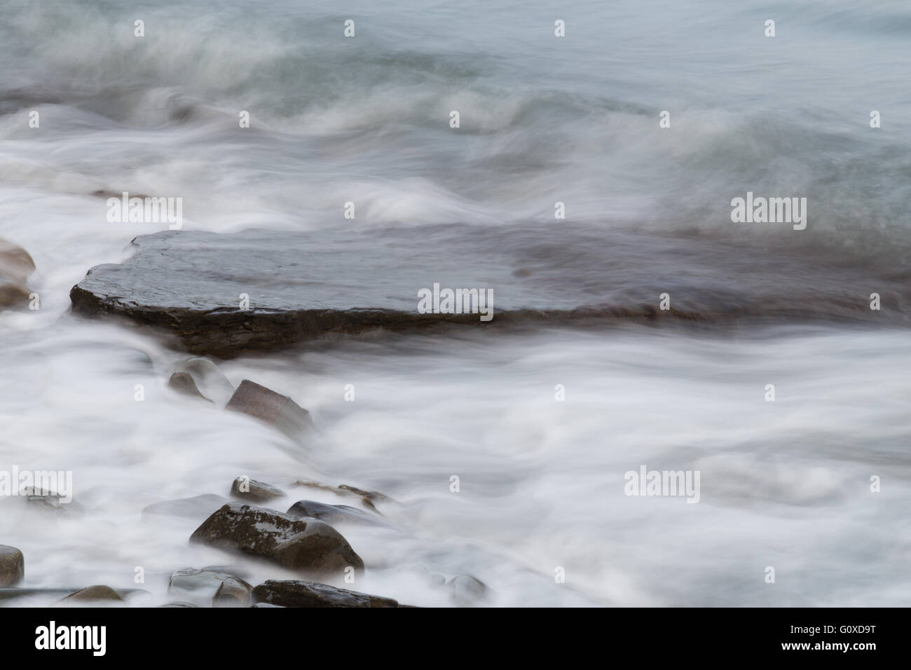 Slow shutter sea waves and rocks on the beach Stock Photo