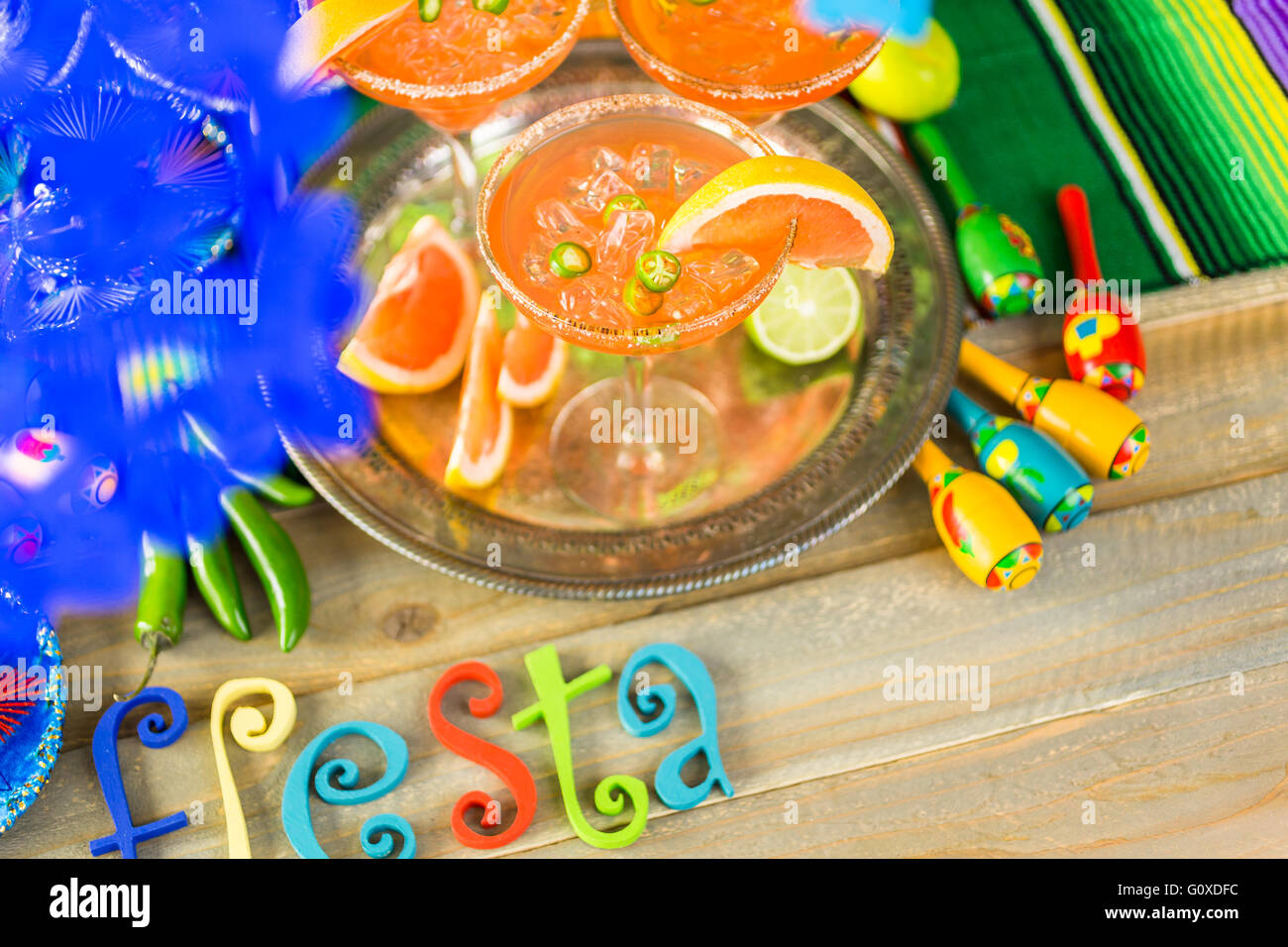 Spicy grapefruit margarita on ice in margarita glasses on the table in the garden. Stock Photo