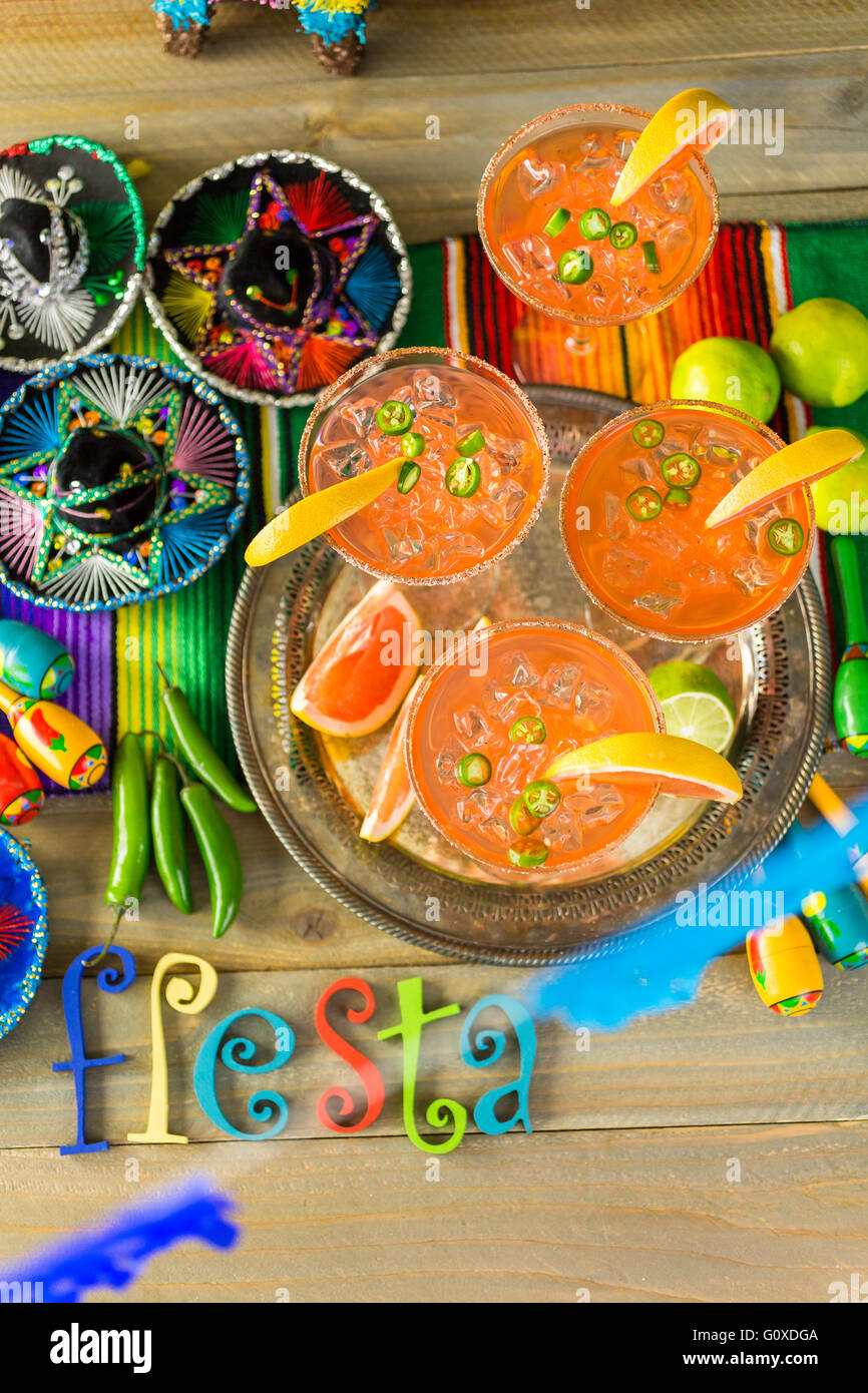 Spicy grapefruit margarita on ice in margarita glasses on the table in the garden. Stock Photo