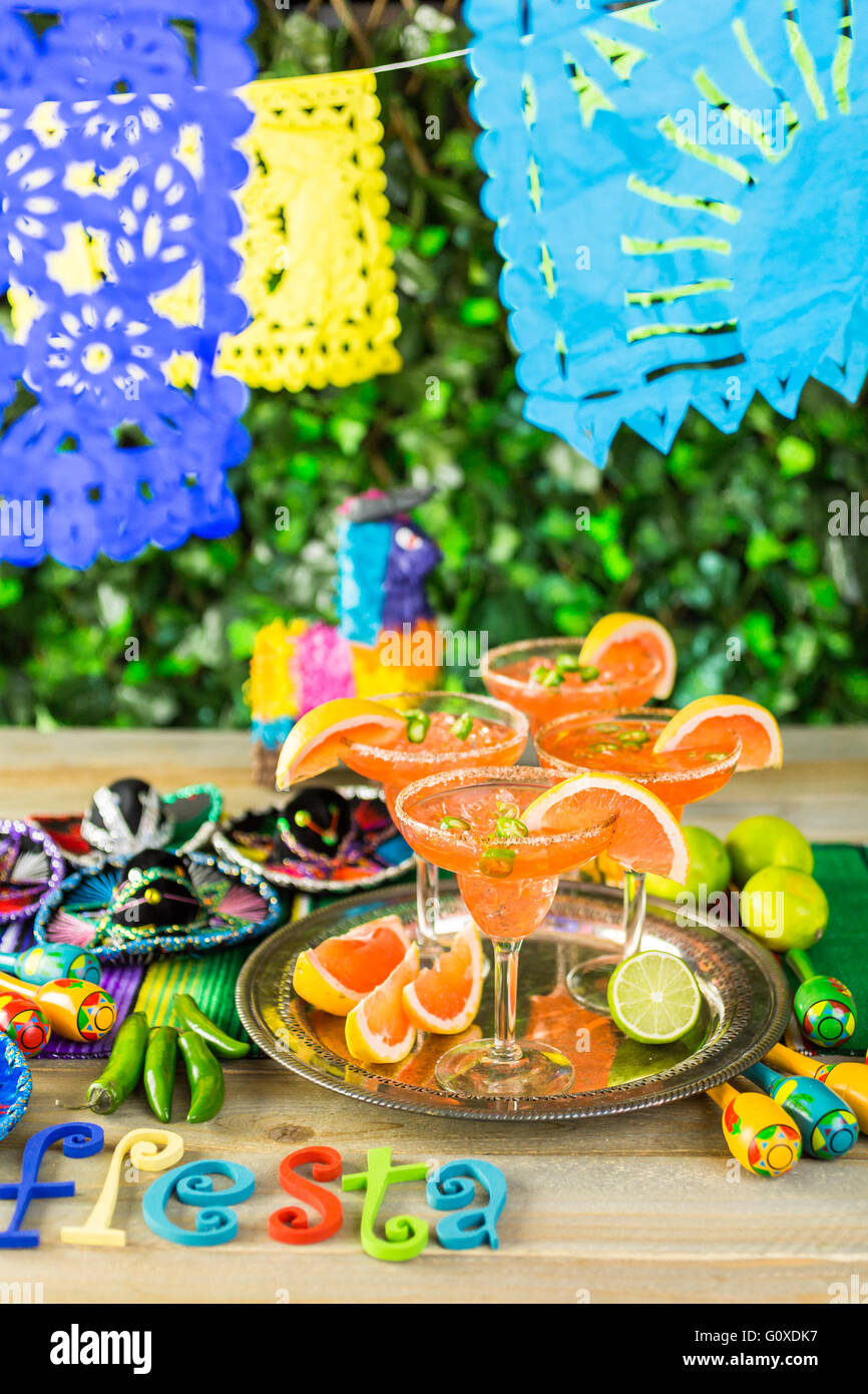 Spicy grapefruit margarita on ice in margarita glasses on the table in the garden. Stock Photo