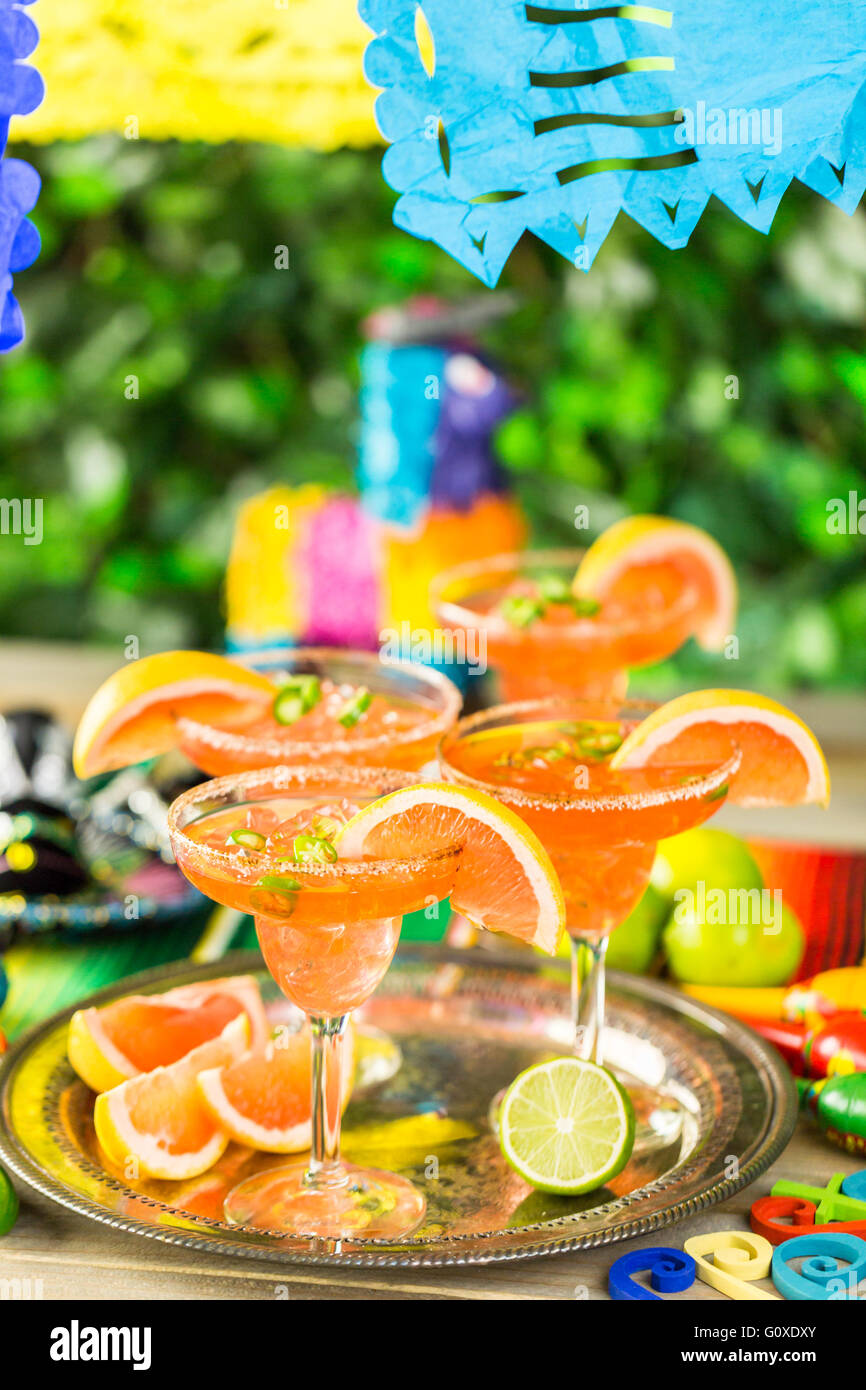 Spicy grapefruit margarita on ice in margarita glasses on the table in the garden. Stock Photo