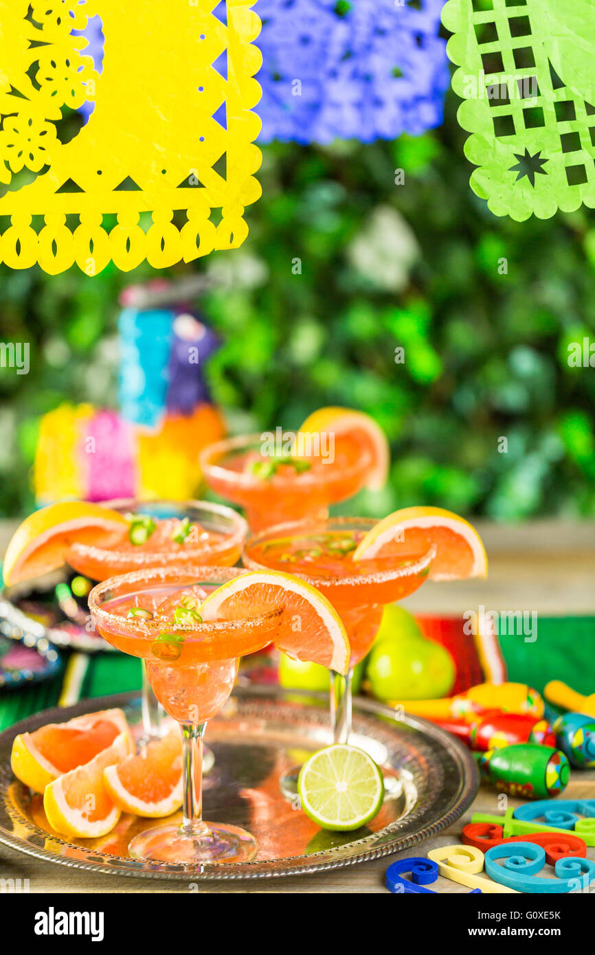 Spicy grapefruit margarita on ice in margarita glasses on the table in the garden. Stock Photo