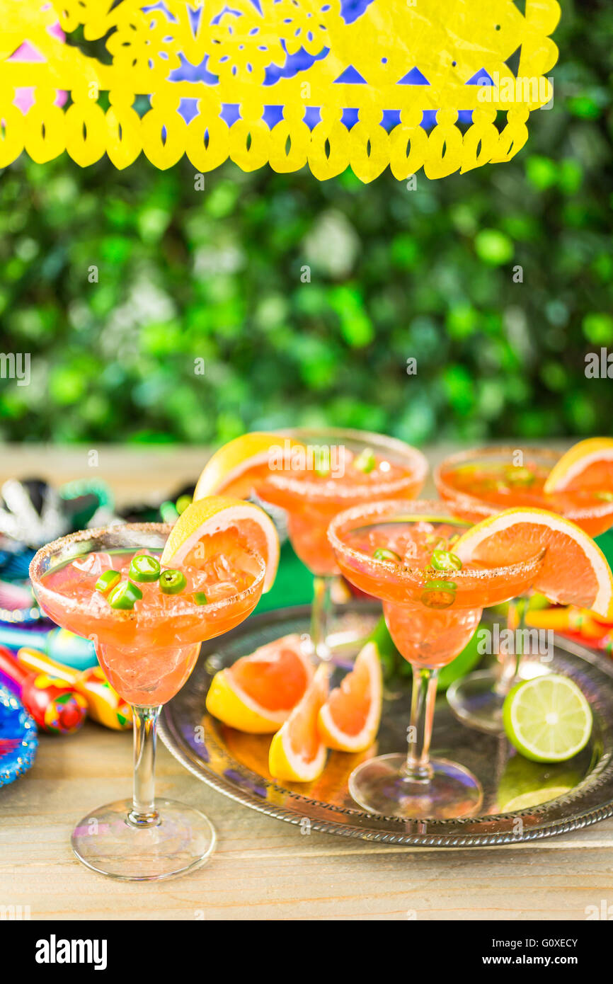 Spicy grapefruit margarita on ice in margarita glasses on the table in the garden. Stock Photo