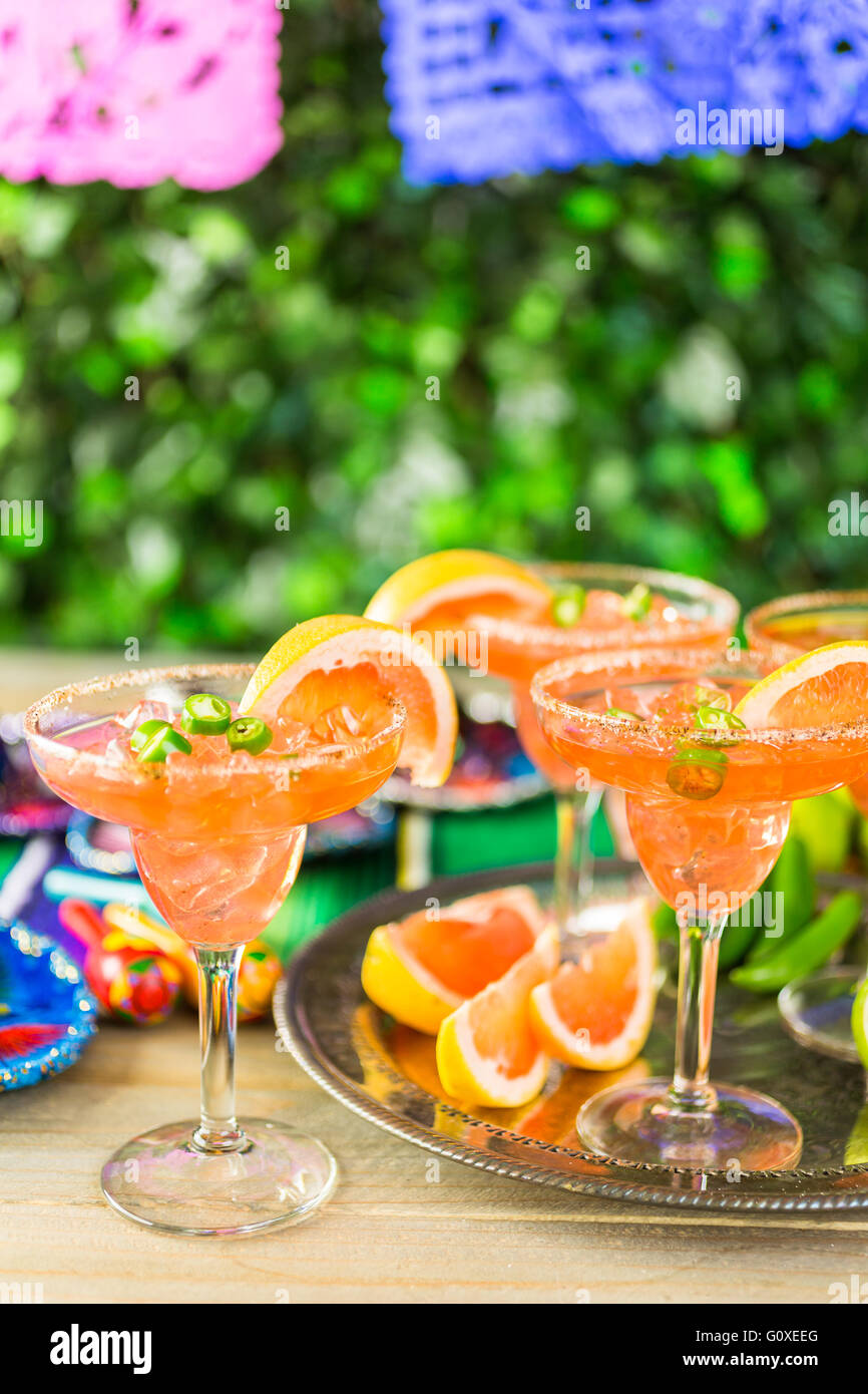 Spicy grapefruit margarita on ice in margarita glasses on the table in the garden. Stock Photo