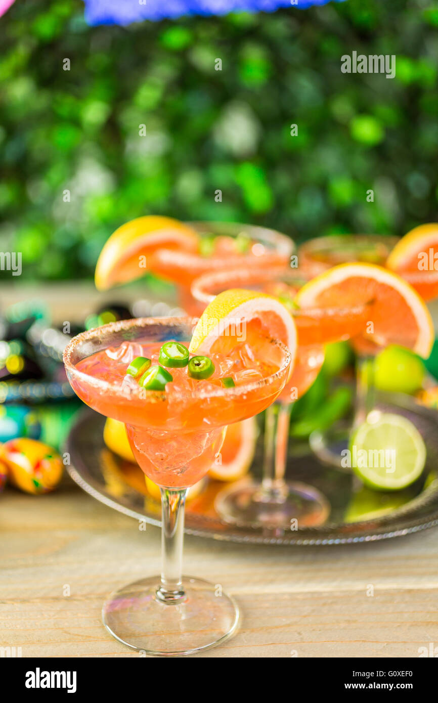 Spicy grapefruit margarita on ice in margarita glasses on the table in the garden. Stock Photo