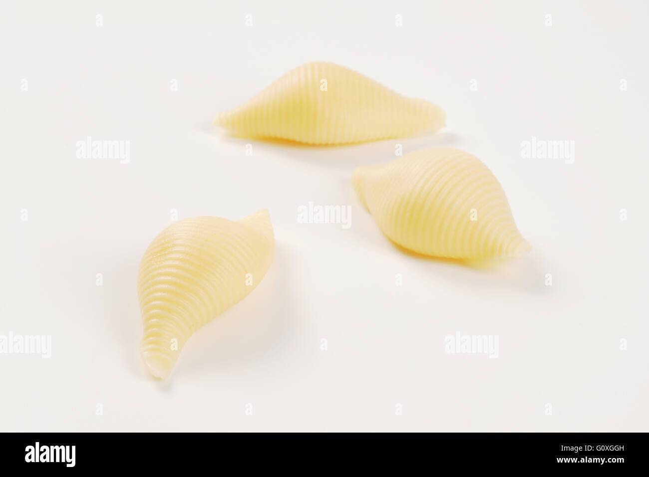 three pieces of pasta shells on white background - close up Stock Photo ...