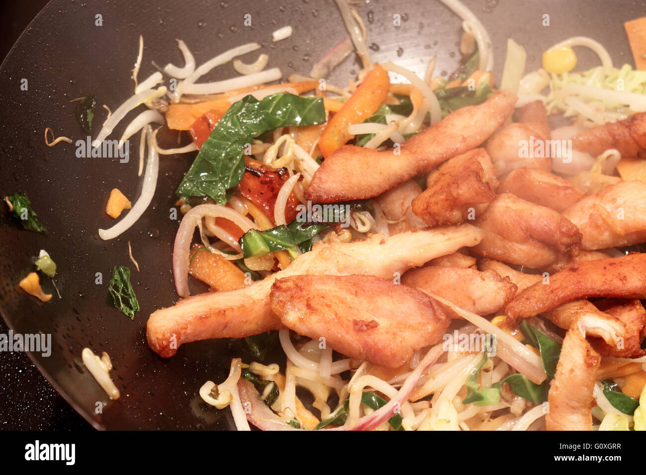 Cooking a chicken stir fry in a wok Stock Photo - Alamy