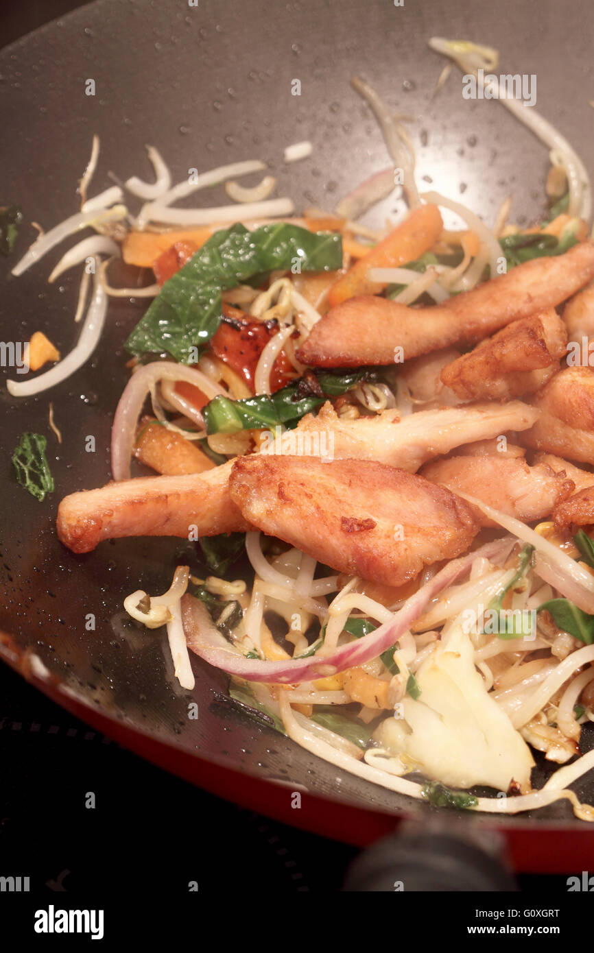 Cooking a chicken stir fry in a wok Stock Photo - Alamy