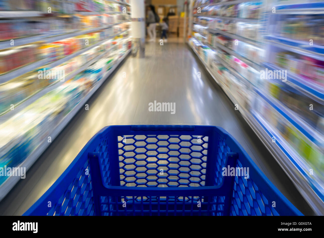 Shopping cart in a supermarket, with blurred shelves in the background Stock Photo