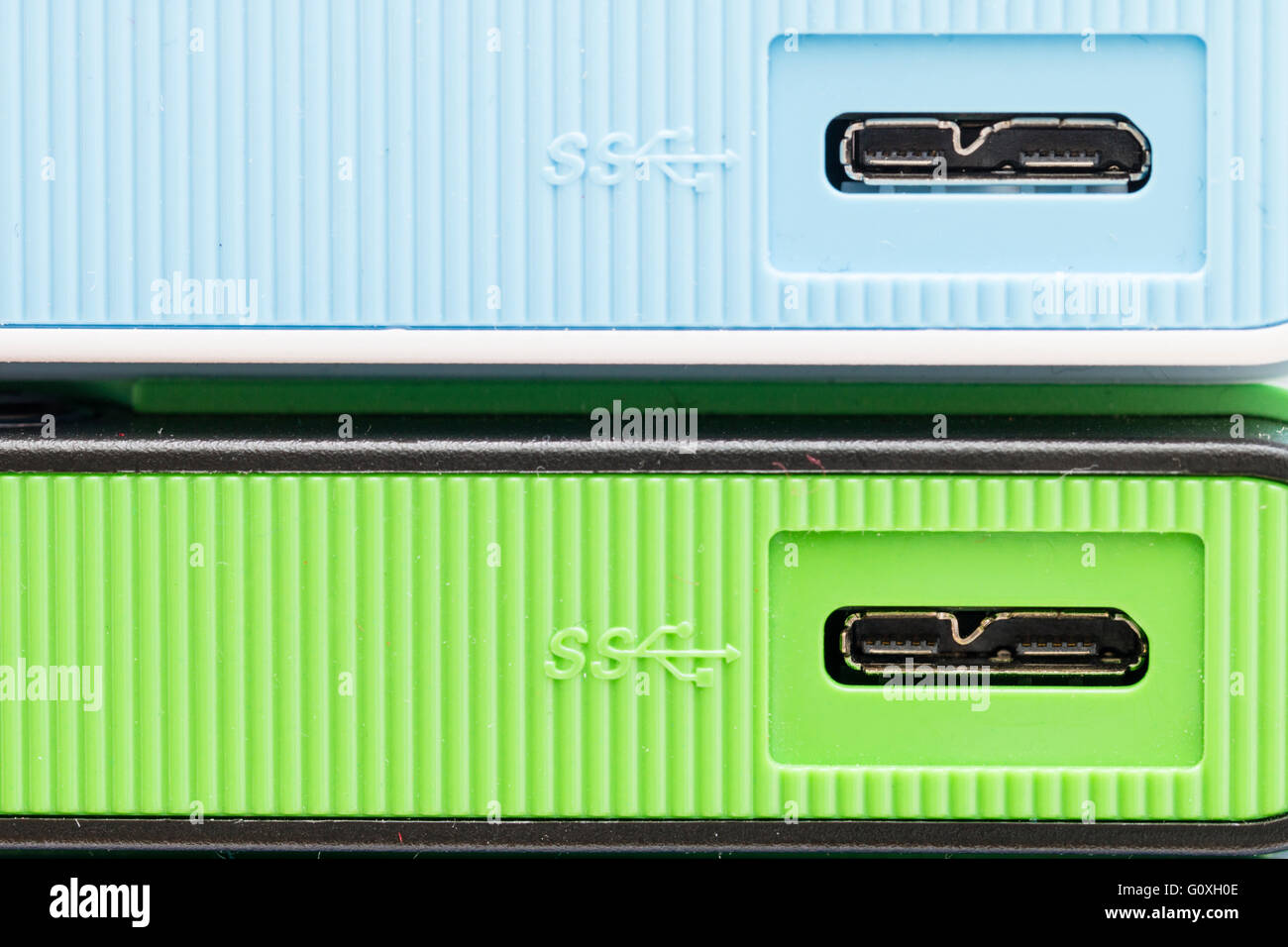 Two portable hard drives, one pale green, other pale blue, USB 3 connection socket. No brand name visible. Stock Photo