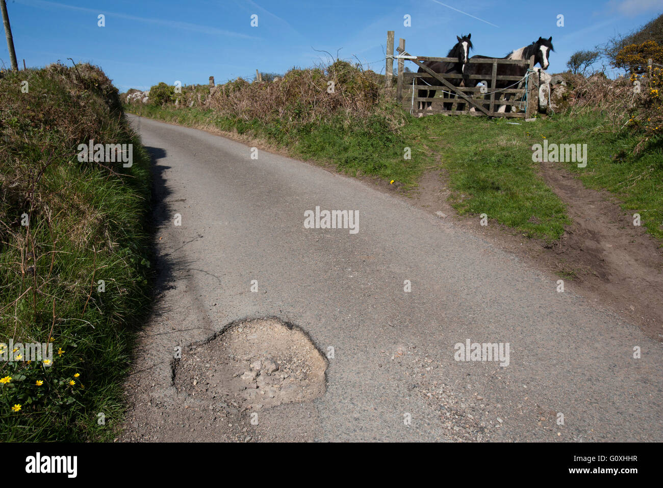 Countryside potholes in the road cause damage to cars and are a danger to unsuspecting motorcyclists and cyclists pot hole Stock Photo