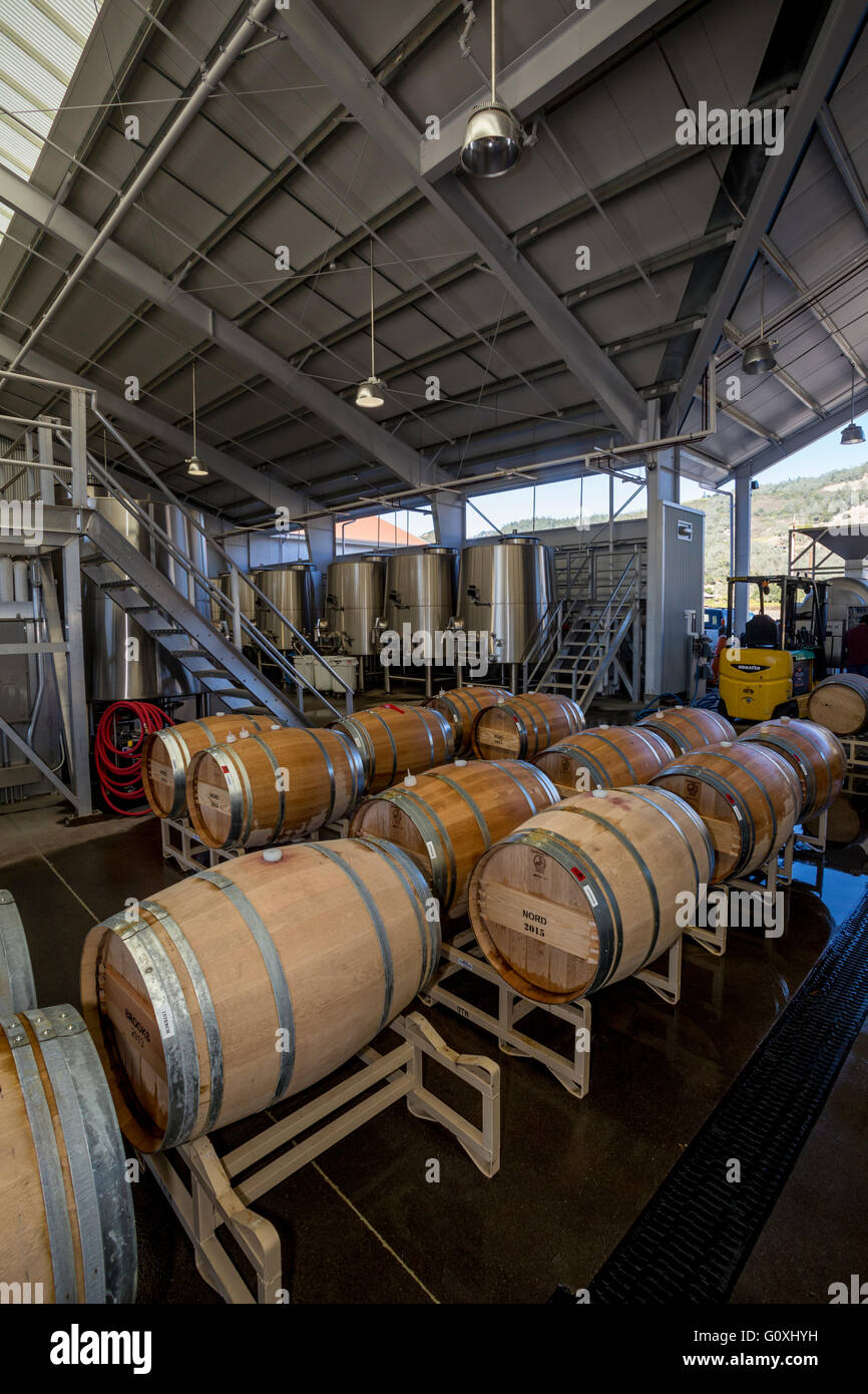 Topping up wine barrel in fermentation area at Mending Wall Winery
