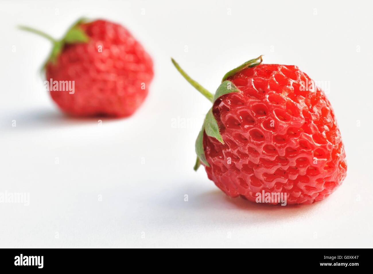 Two strawberries isolated on white background Stock Photo - Alamy