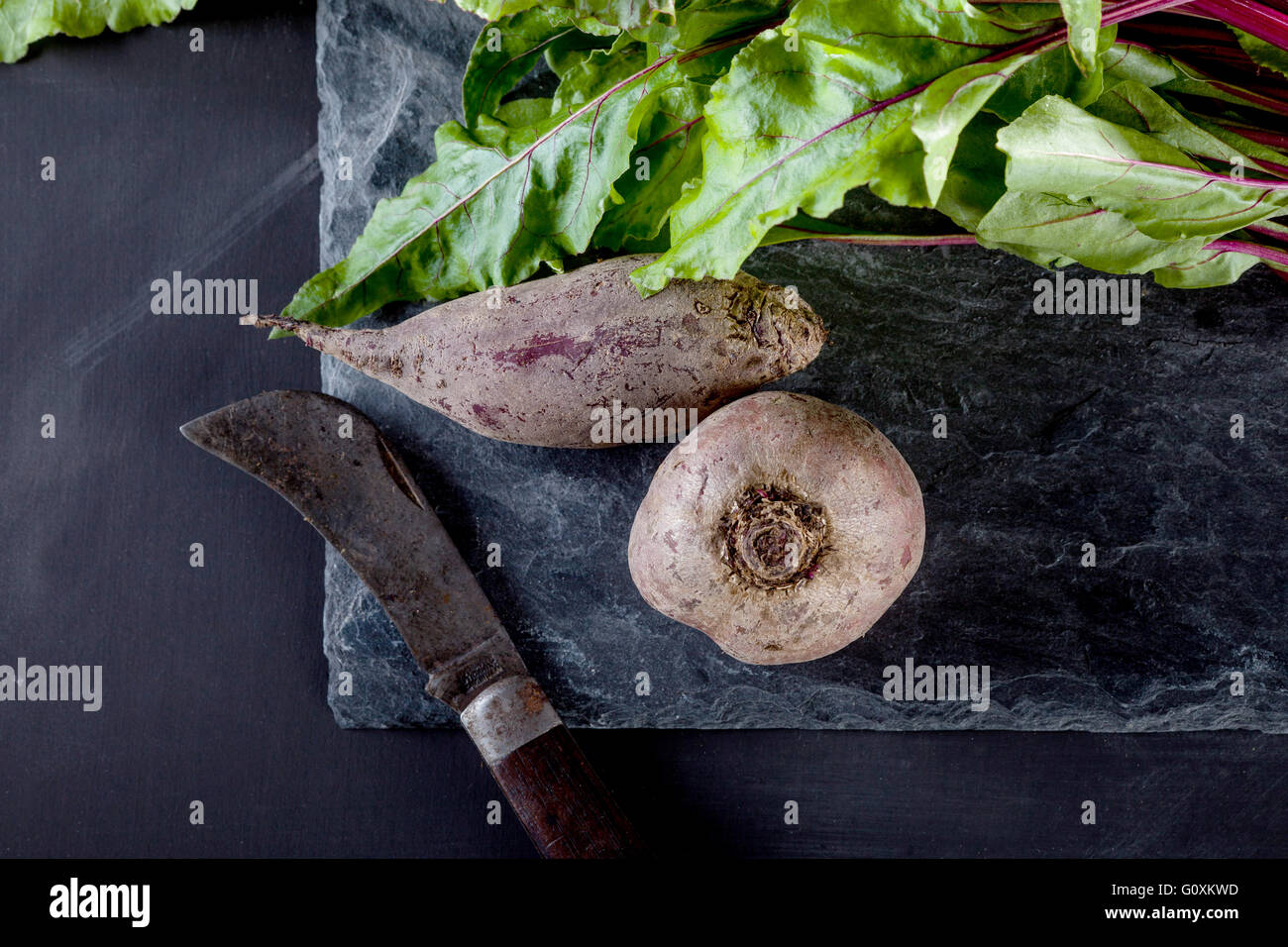 Bunch of beetroot's on the stone and blackboard with old style knife ...