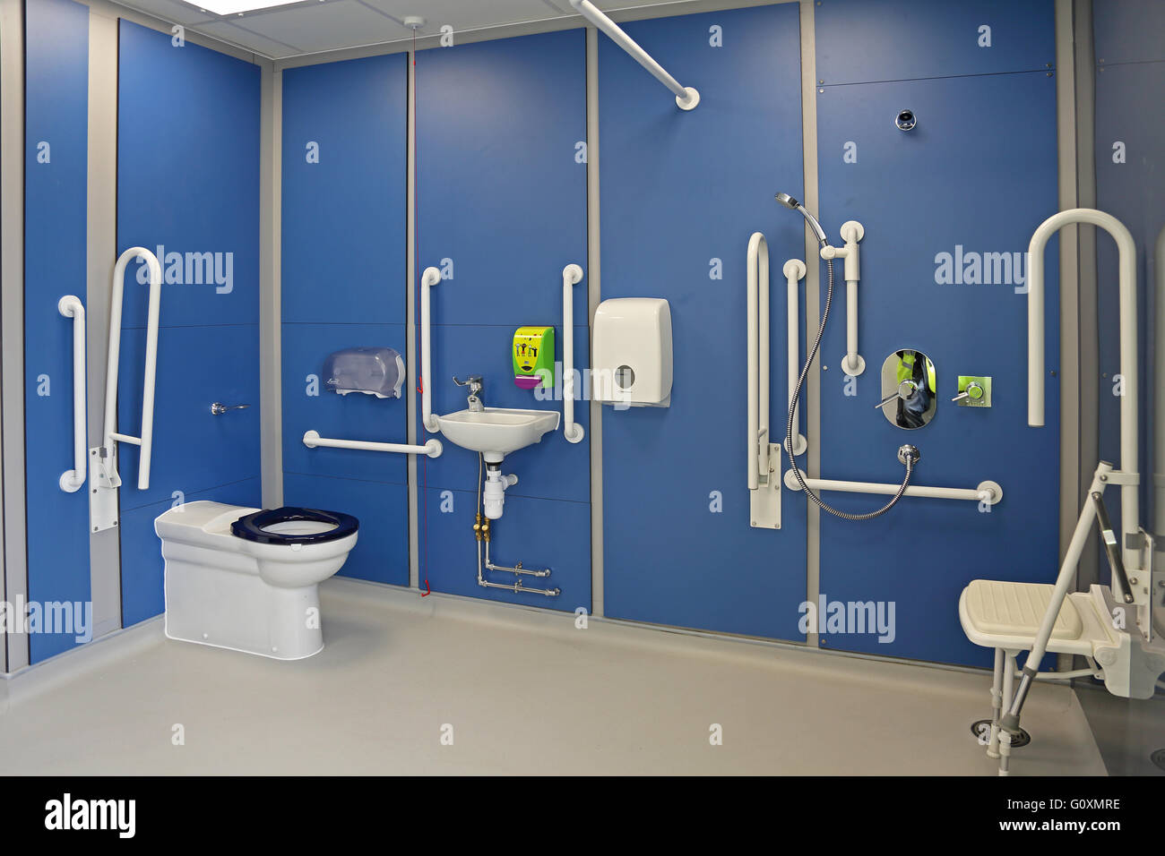 A disabled toilet and shower room in a new London primary school. Shows support rails shower seat and plumbing equipment Stock Photo