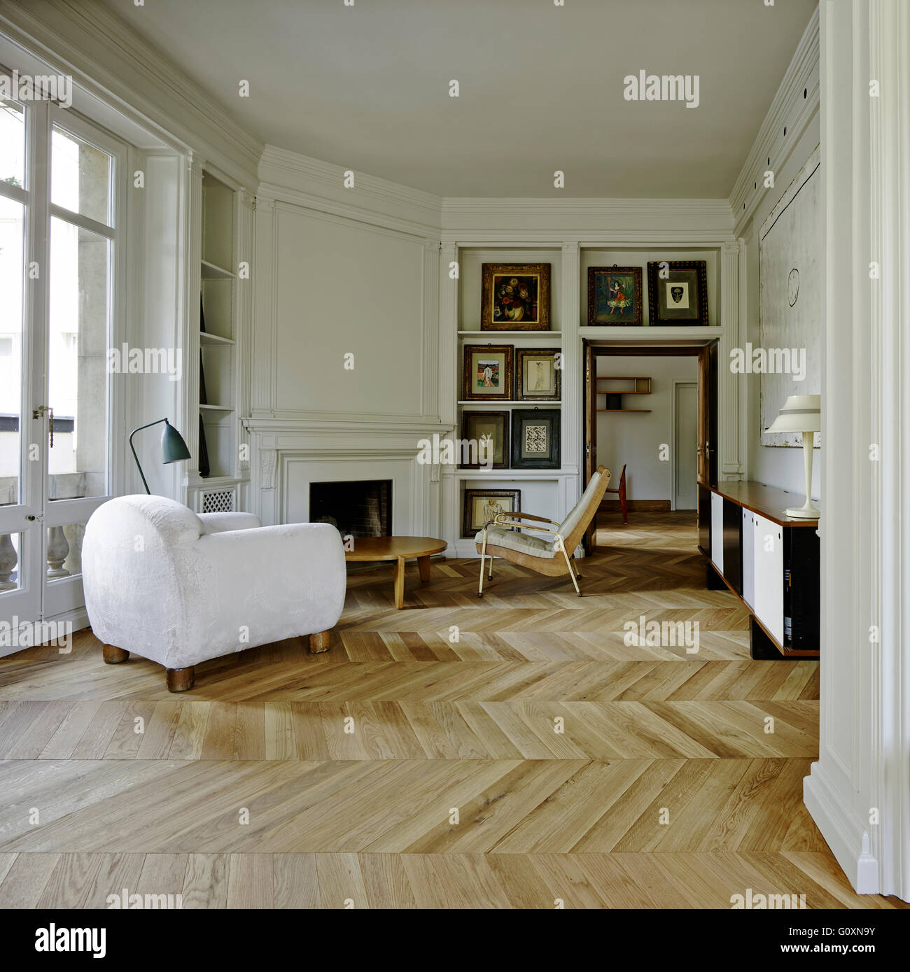 Spacious, open plan living room with parquet flooring and  a mix of traditional features and contemporary furniture. Stock Photo