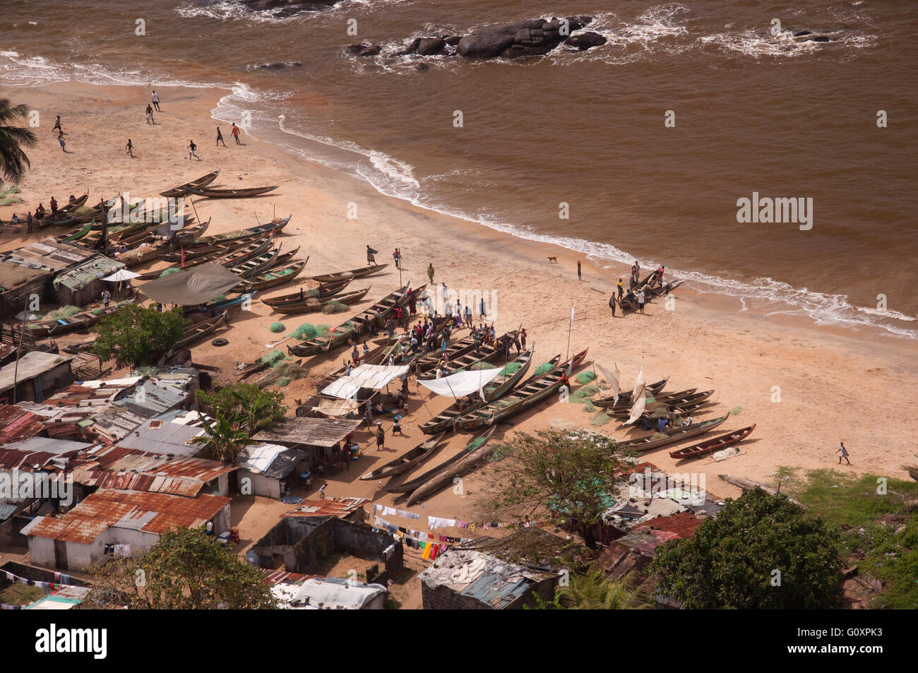 People, fishing nets and canoes make a for very interesting composition of everyday life on a beach west of Monrovia Liberia. Stock Photo