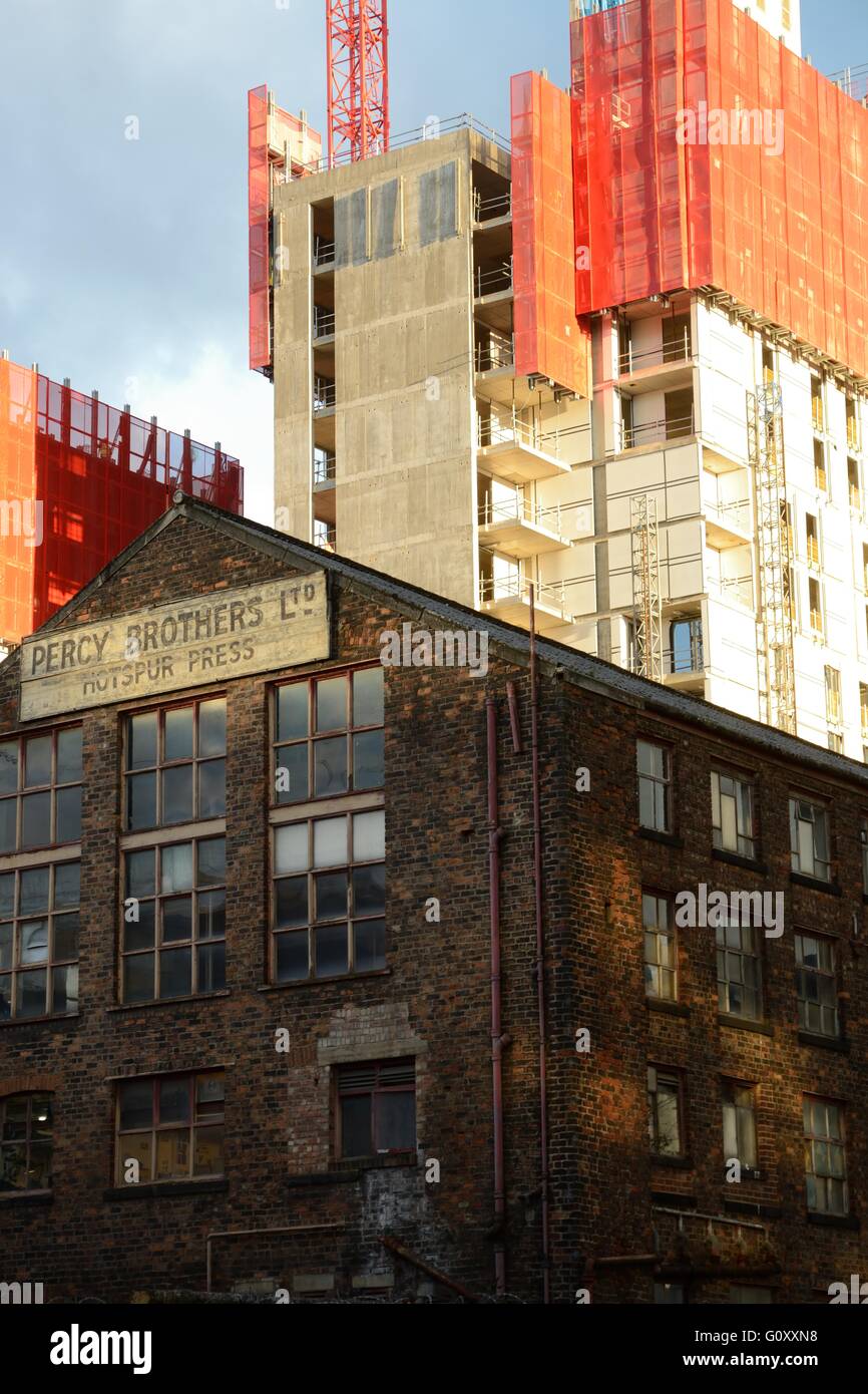 Old mill in the centre of Manchester against a backdrop of a new development. Stock Photo