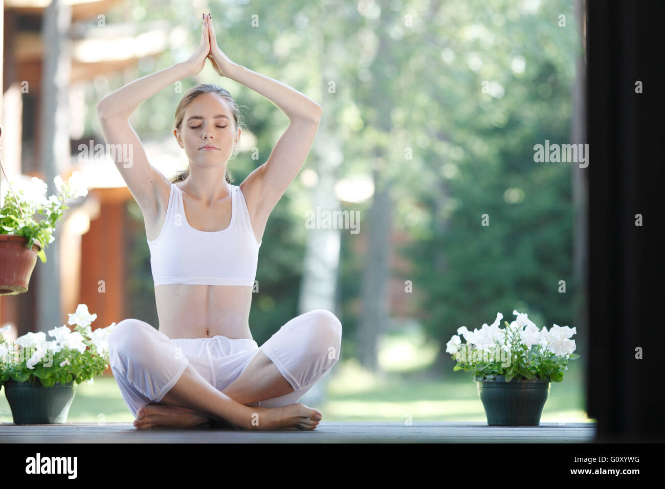 Young woman doing yoga lotus exercise outdoors Stock Photo