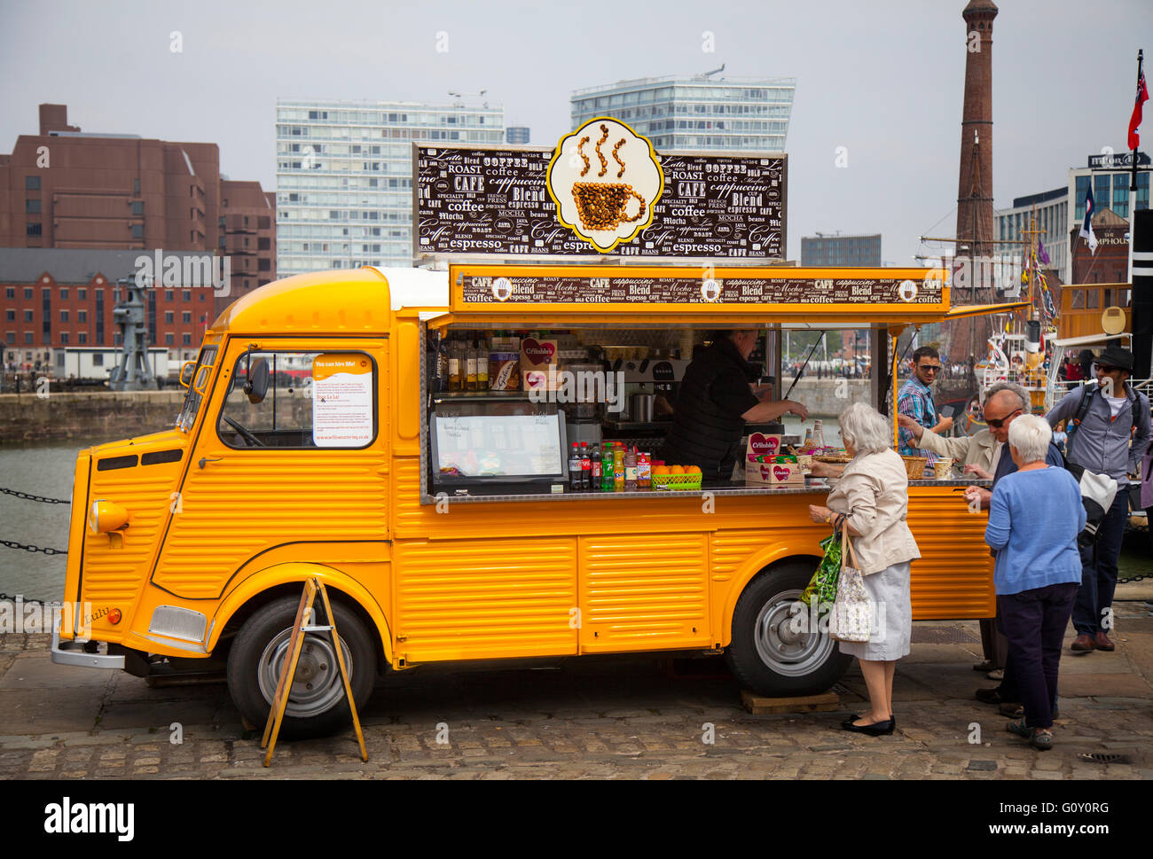 Queue outside Classic yellow Citroen 'H' ice cream, coffee carts, coffee vans, catering van. A french vehicle, food truck converted to selling foods and drinks, Liverpool, Merseyside, UK Stock Photo