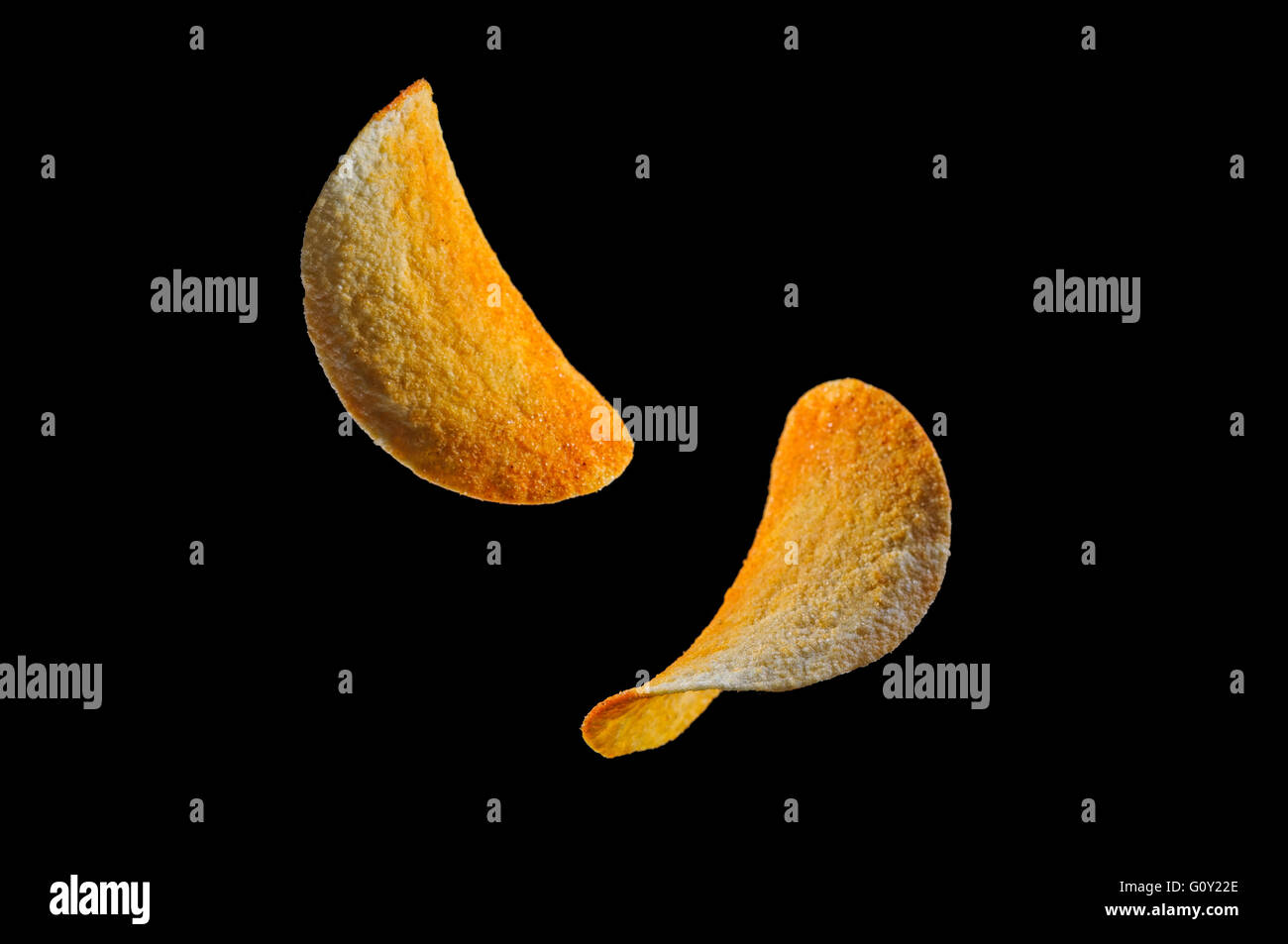 Falling potato saddle-form chips isolated on black background Stock Photo
