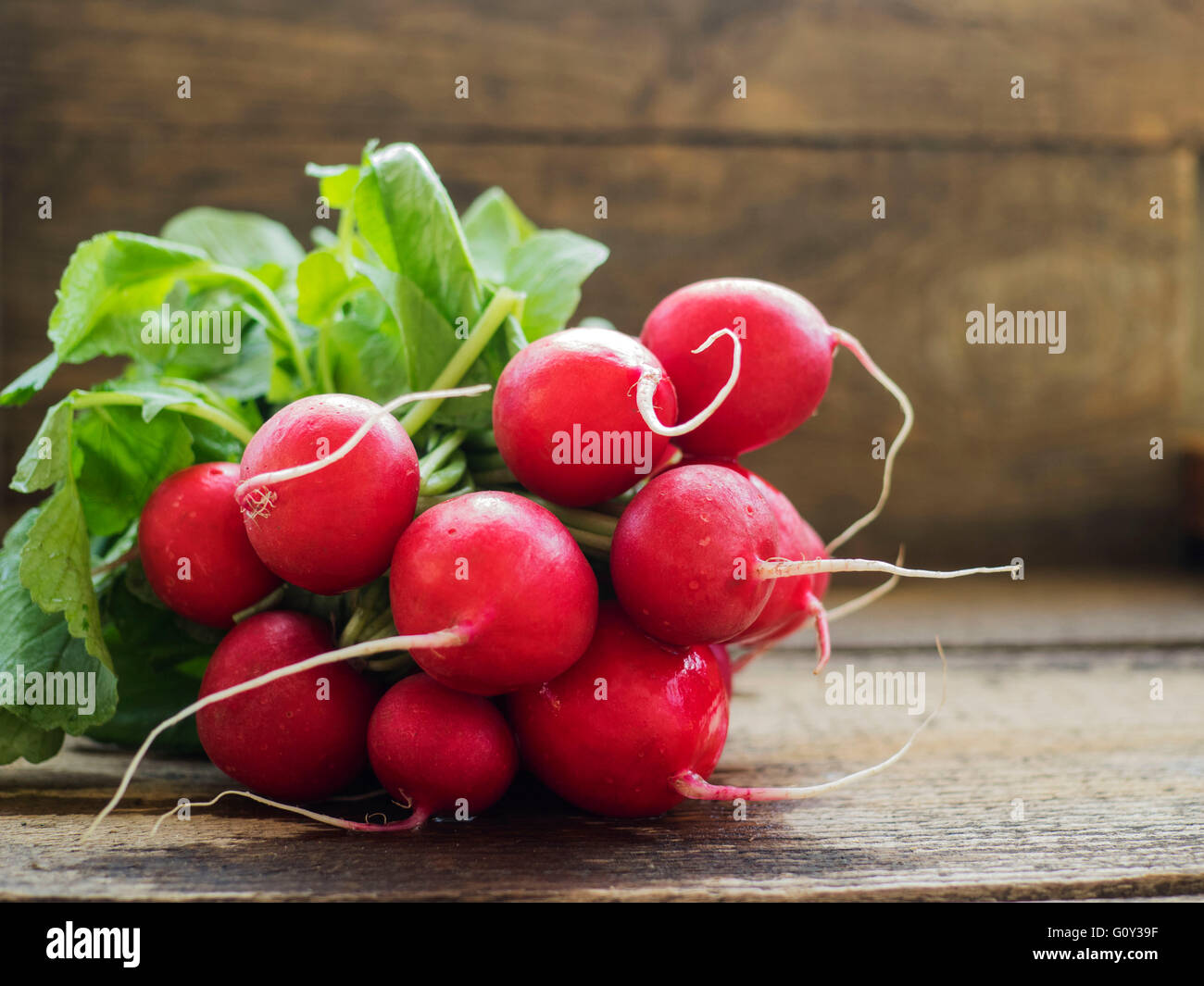 Bunch of fresh radishes on wooden table Stock Photo