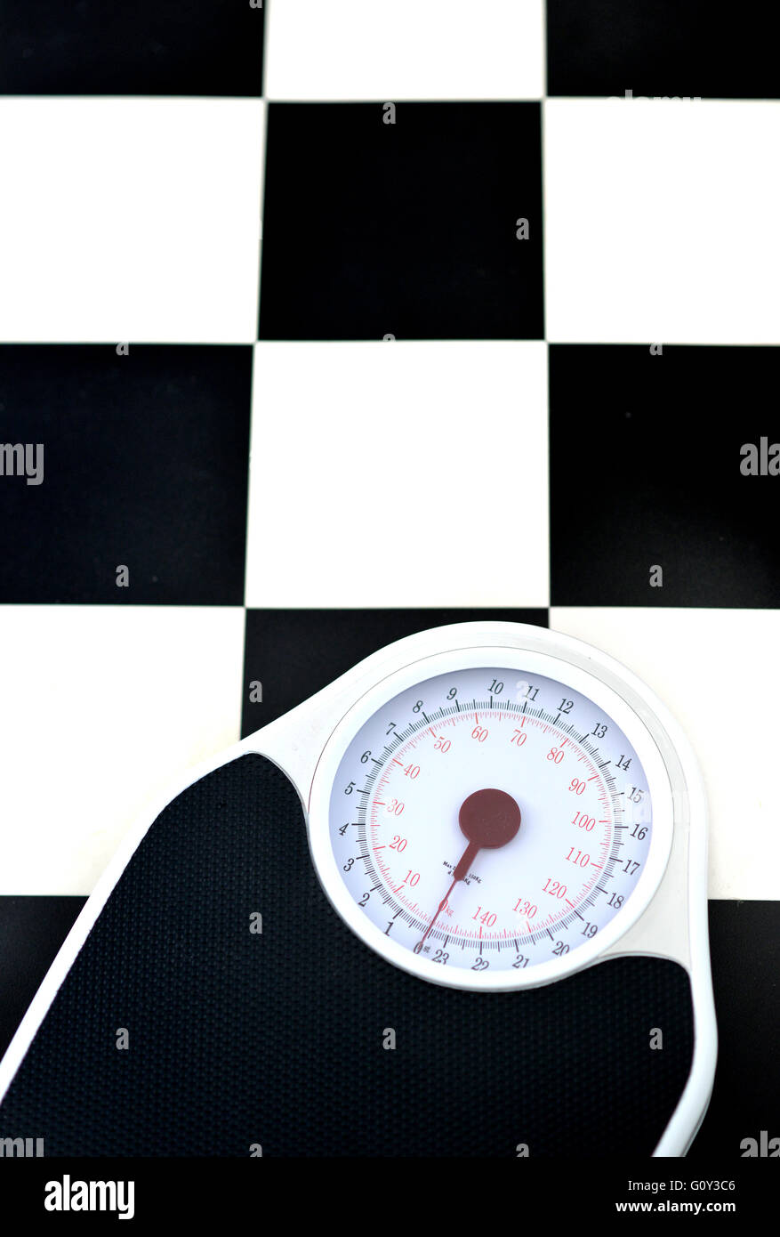 Bathroom scales on checkered floor Stock Photo