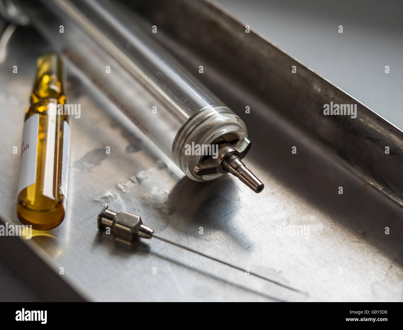 Close-up of vintage glass syringe on medical tray Stock Photo