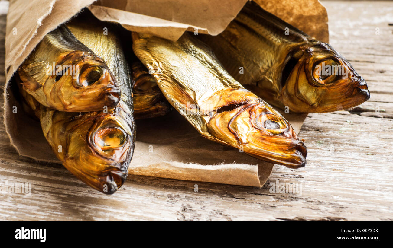 Smoked herring fish wrapped in brown paper Stock Photo