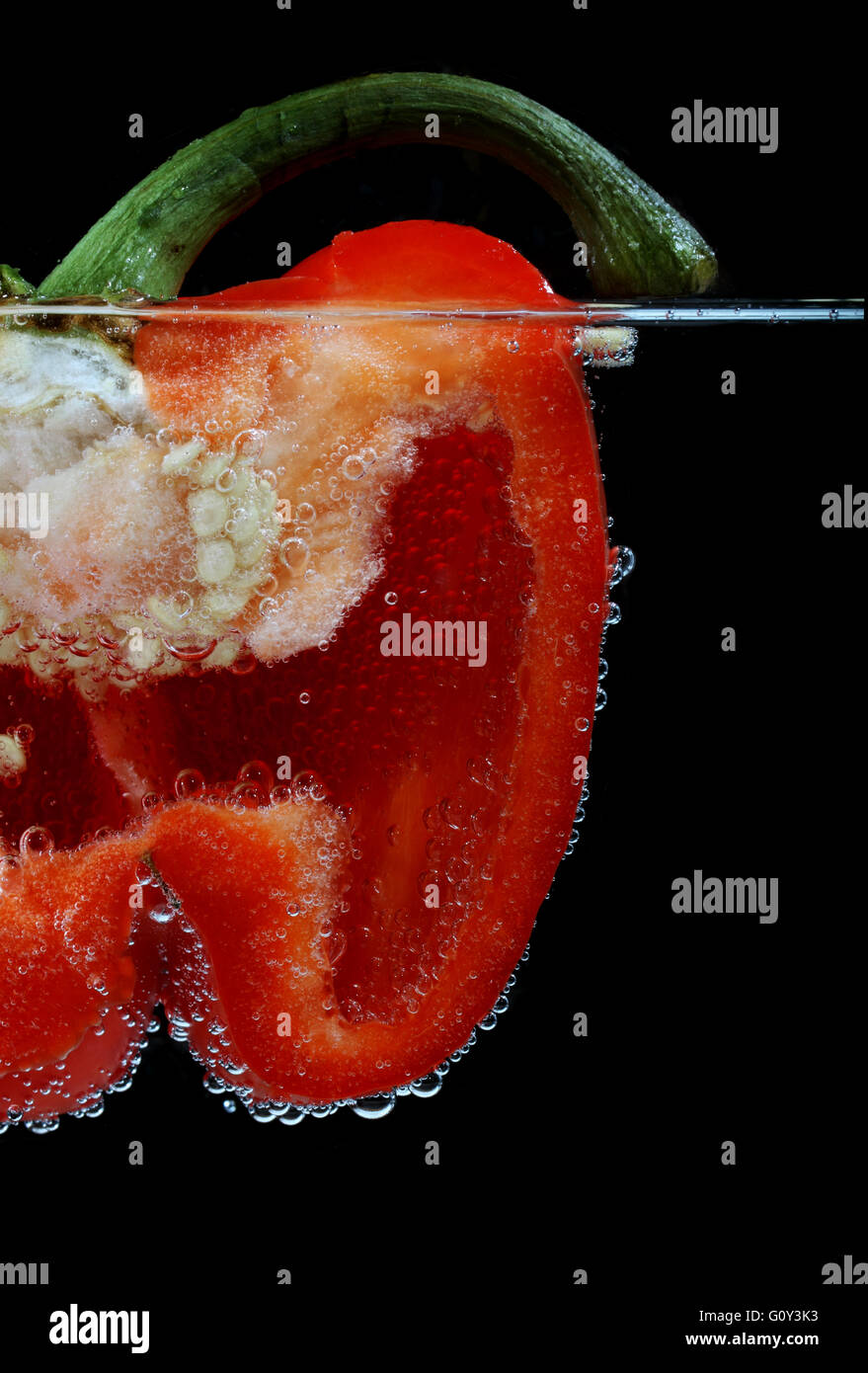 Close-up of halved red bell pepper in sparkling water Stock Photo