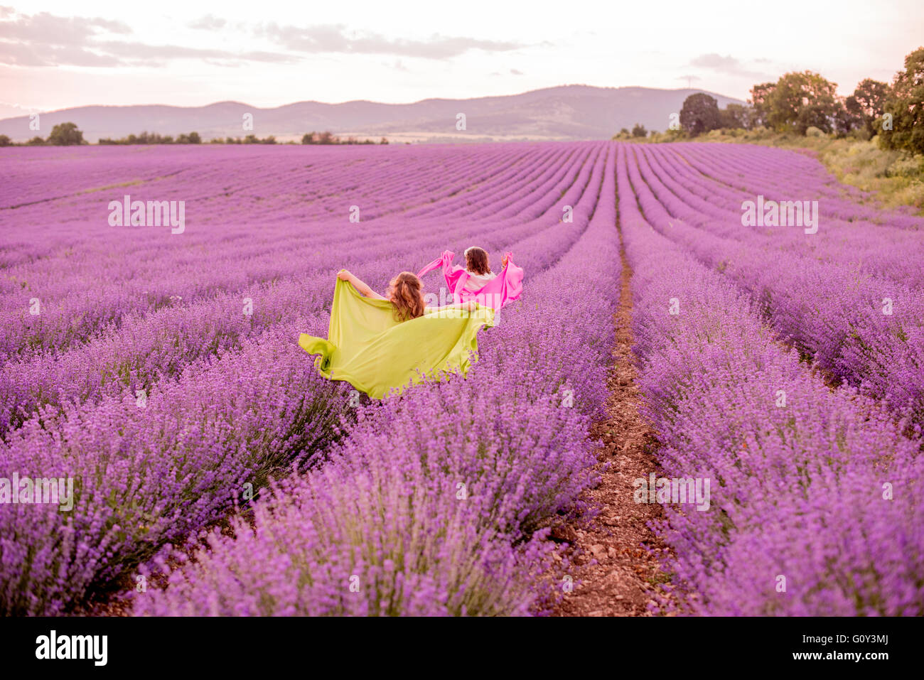 Two girls running through lavender field, Kazanlak, Bulgaria Stock Photo