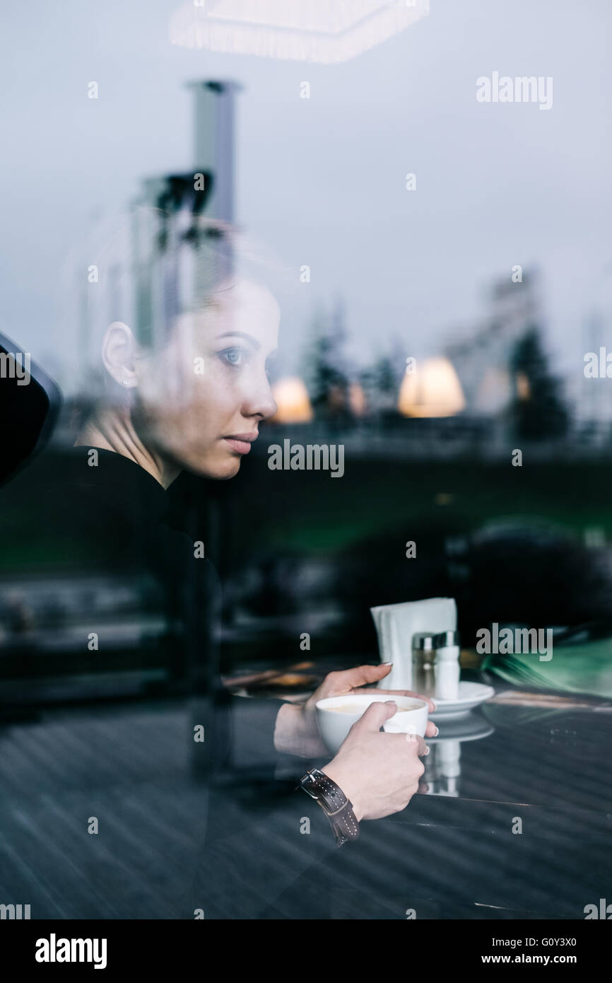 Woman drinking coffee in café Stock Photo