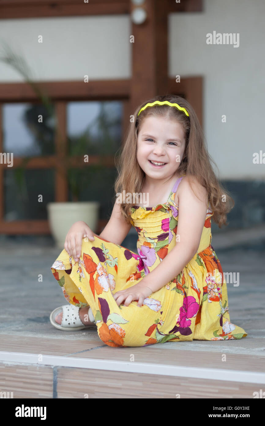 Portrait of a smiling girl sitting on terrace Stock Photo - Alamy