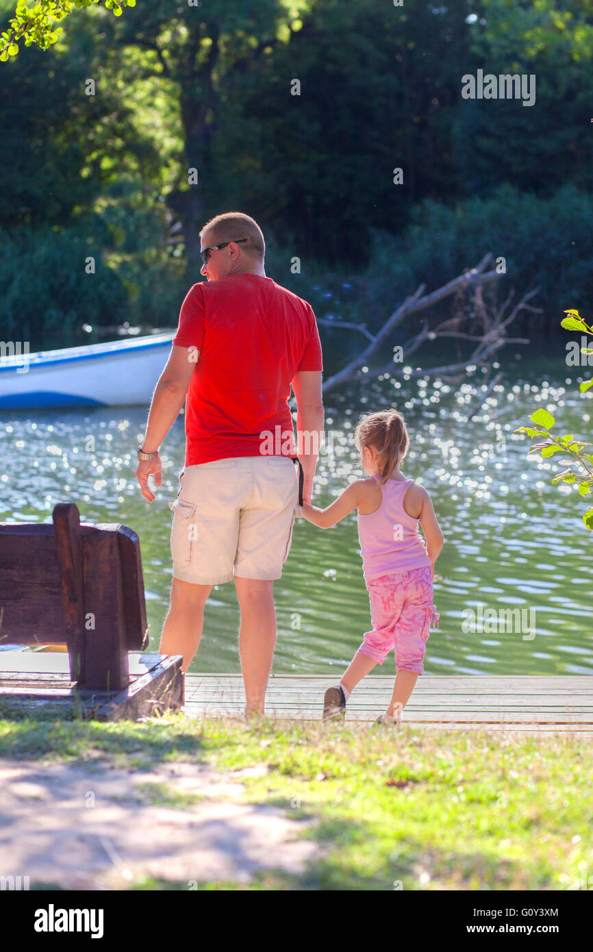 Father and daughter standing by riverbank holding hands Stock Photo - Alamy