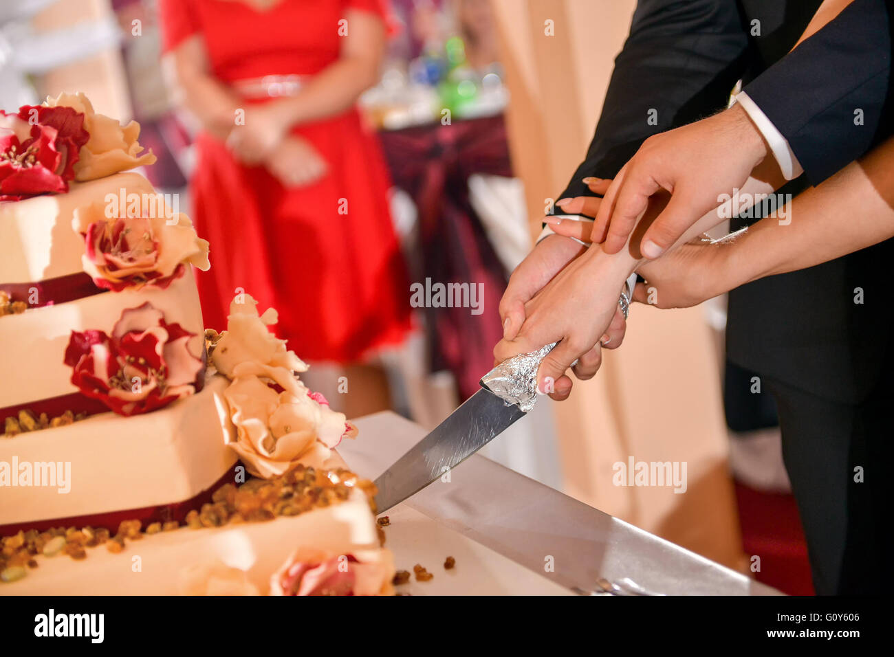 Groom and bride cutting a wedding cake in natural light Stock Photo