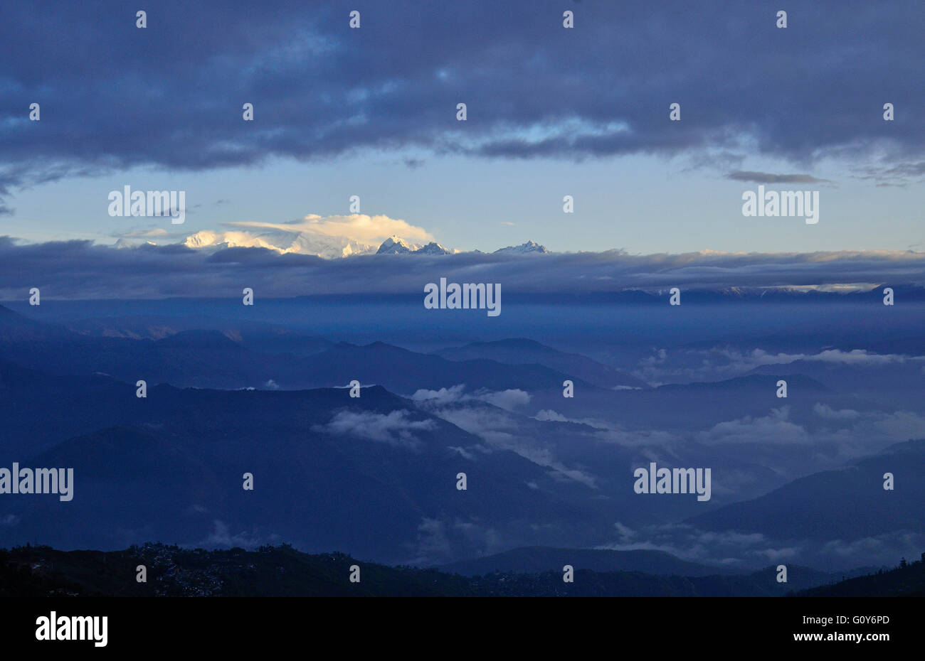 Mt.Kanchenjunga, the Third Highest mountain in the world at 8586 meters, at sunrise with hanging clouds around it, Sikkim, India Stock Photo